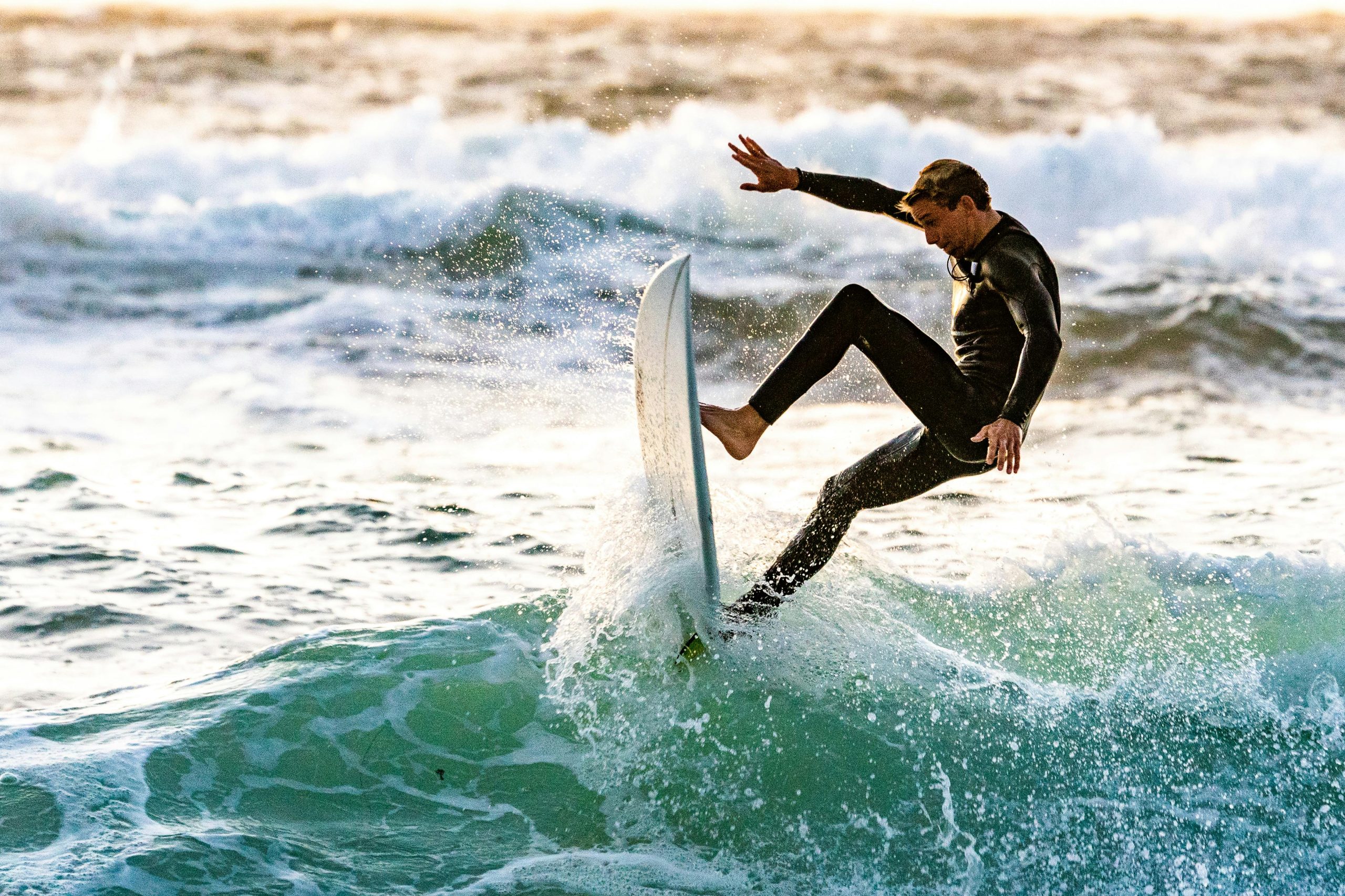 Energetic surfer performing a trick on ocean waves, showcasing skill and excitement.