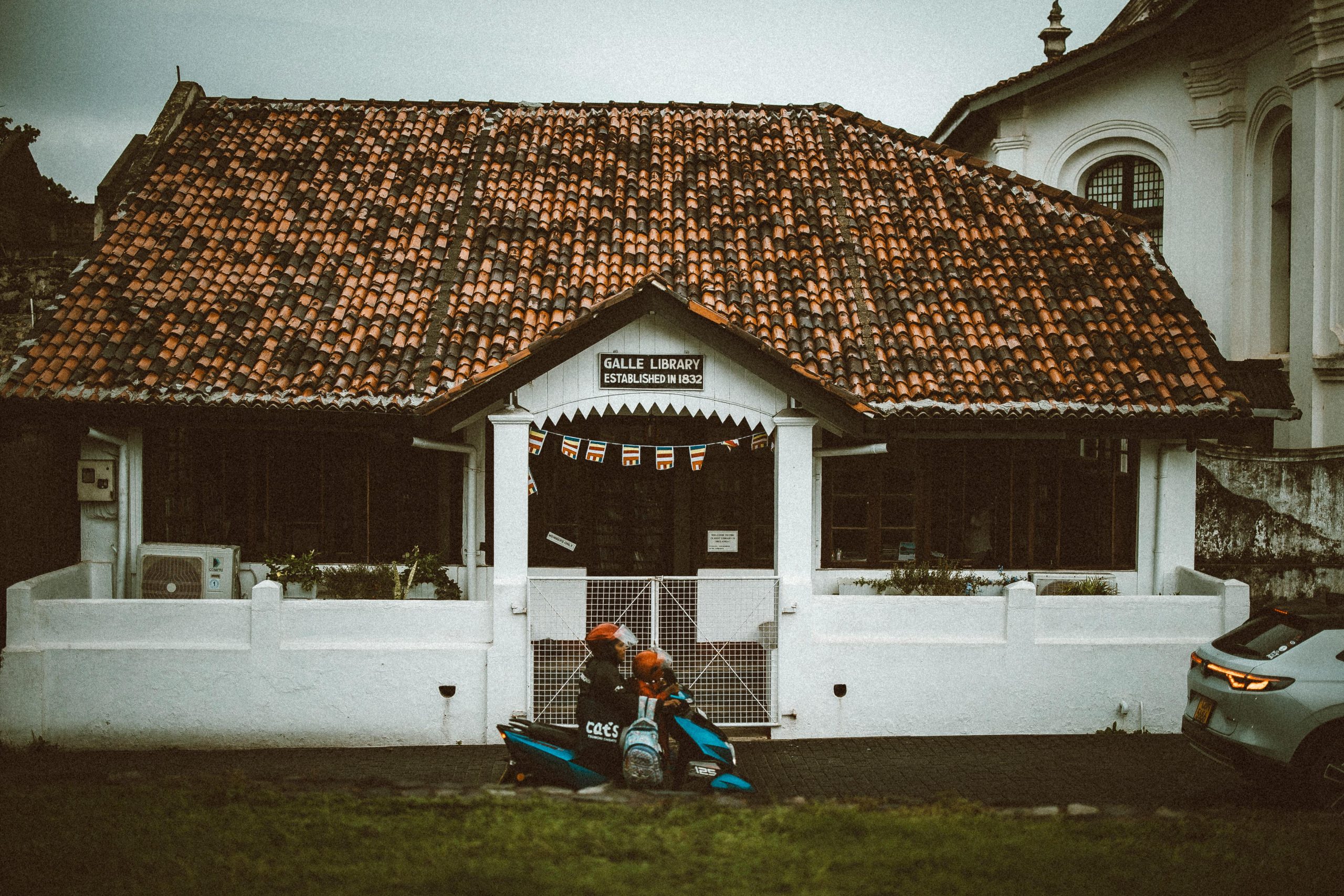 Historic Galle Library with rustic charm and a parked scooter in Sri Lanka.